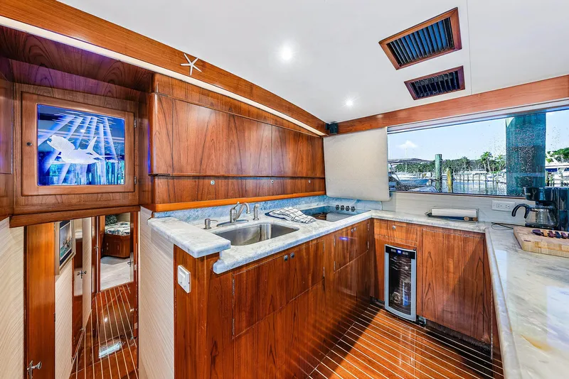 Slide: The Image of Luxurious 1990 Monterey Custom Sportfish yacht kitchen with wooden cabinetry and modern appliances. - 15