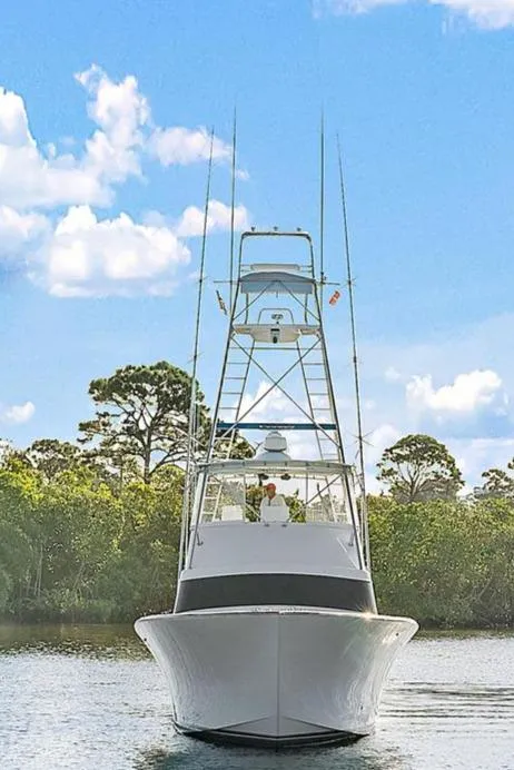 Slide: The Image of 1990 Monterey Custom Sportfish boat on a calm waterway with a clear sky. - 2