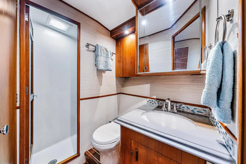 Slide: The Image of 1990 Monterey Custom Sportfish bathroom with shower, sink, and wooden cabinetry. - 20