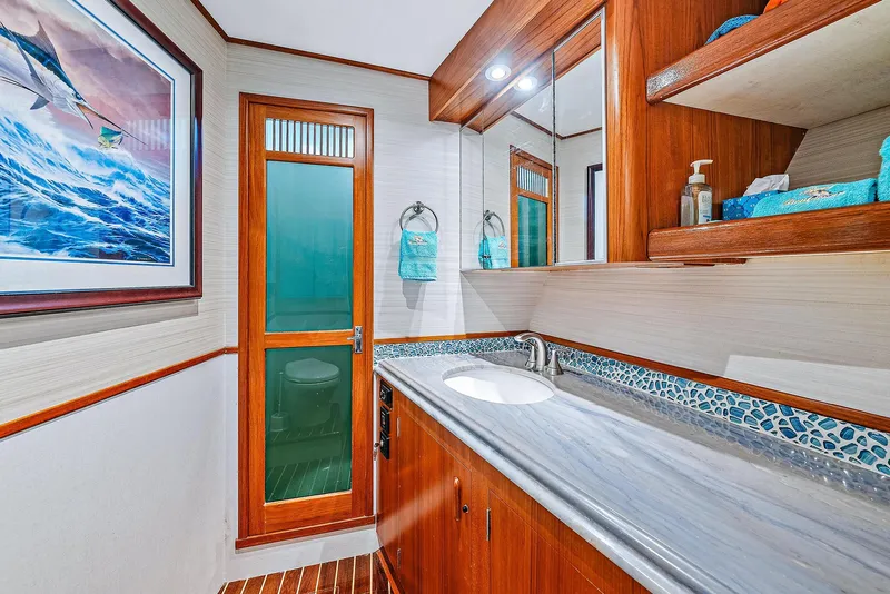 Slide: The Image of 1990 Monterey Custom Sportfish bathroom with modern sink, wooden cabinetry, and nautical decor. - 22