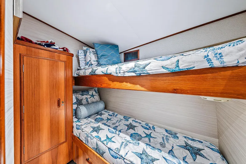 Slide: The Image of 1990 Monterey Custom Sportfish cabin with wooden bunk beds and starfish-themed bedding. - 23