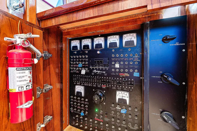 Slide: The Image of Electrical control panel of a 1990 Monterey Custom Sportfish boat with a fire extinguisher. - 24