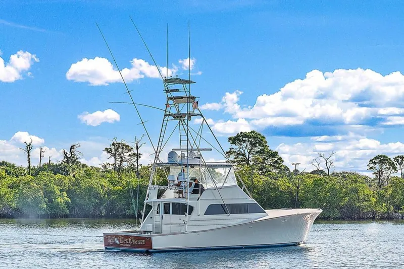 Slide: The Image of 1990 Monterey Custom Sportfish boat cruising on a sunny day with blue sky and clouds. - 26