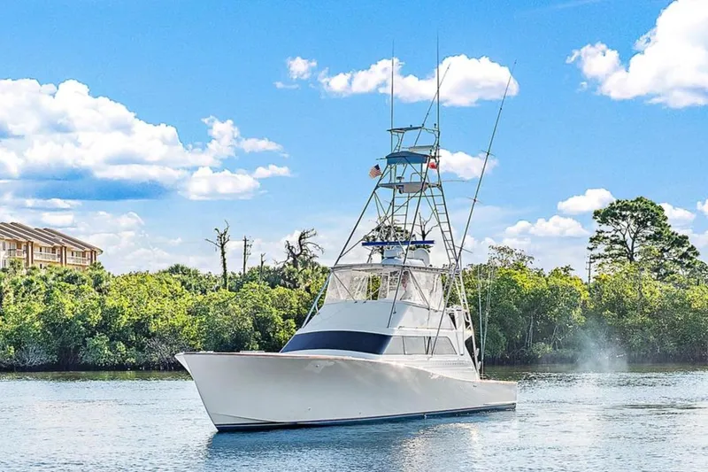Slide: The Image of 1990 Monterey Custom Sportfish boat on a calm river with lush greenery. - 27