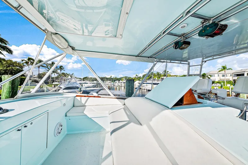 Slide: The Image of 1990 Monterey Custom Sportfish boat interior with white seating and marina view. - 7