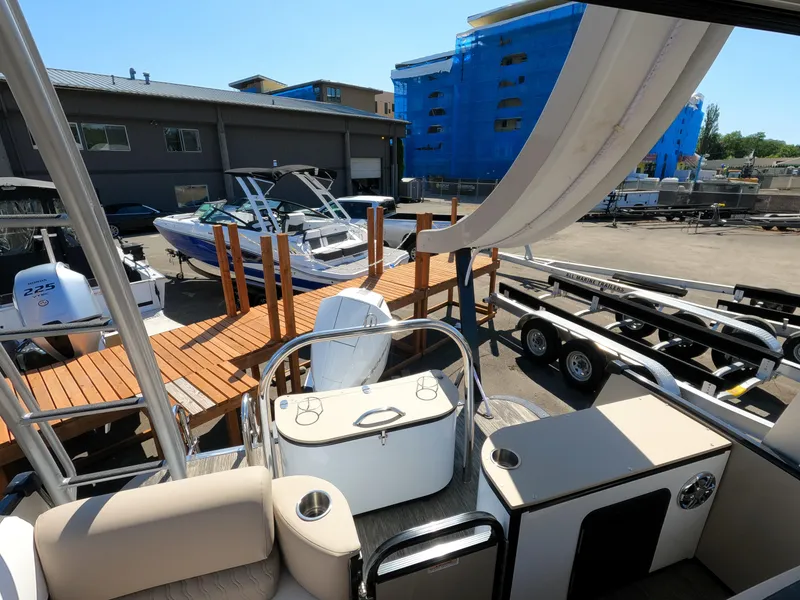 Slide: The Image of 2024 Avalon Catalina Entertainer Funship at a marina with other boats and trailers. - 13