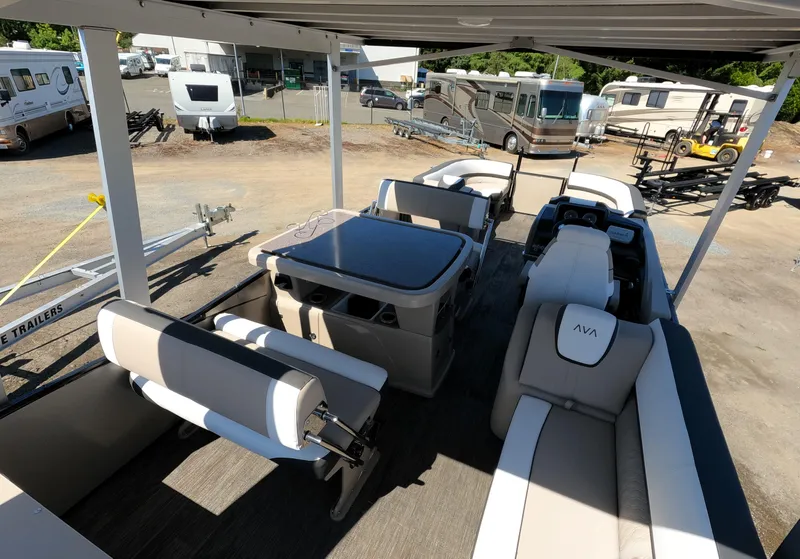 Slide: The Image of 2024 Avalon Catalina Entertainer Funship interior with seating and table, parked at a dealership. - 20