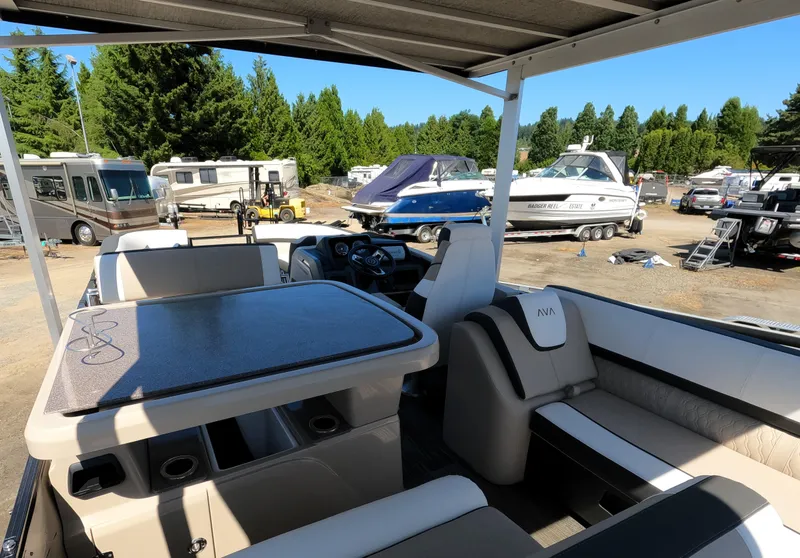 Slide: The Image of 2024 Avalon Catalina Entertainer Funship interior with seating and table, parked in a marina. - 21