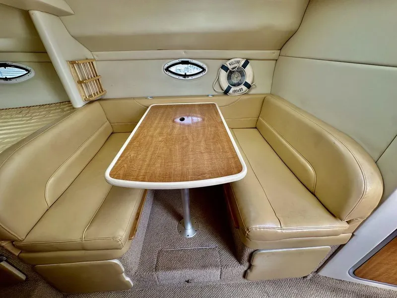 Slide: The Image of 2002 Custom 33SCR boat interior with tan leather seating and wooden table. - 13