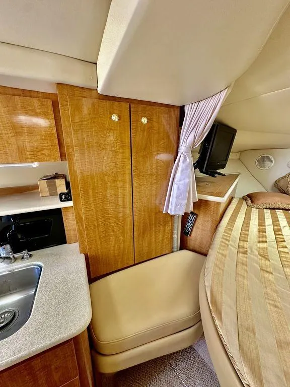 Slide: The Image of Interior of a 2002 Custom 33SCR boat with wood cabinets and a cozy sleeping area. - 15
