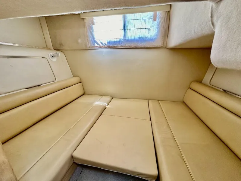Slide: The Image of Interior cabin of a 2002 Custom 33SCR boat with beige seating and window. - 17