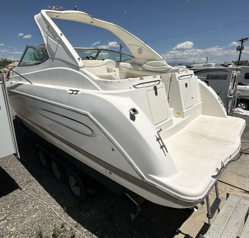 Slide: The Image of White 2002 Custom 33SCR boat on trailer, parked outdoors under clear sky. - 3