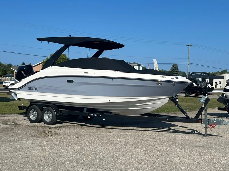 The Image of 2024 Sea Ray SLX 260 Outboard boat on trailer, parked outdoors. - 0