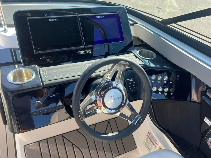 Slide: The Image of 2024 Sea Ray SLX 260 Outboard dashboard with steering wheel and digital displays. - 10