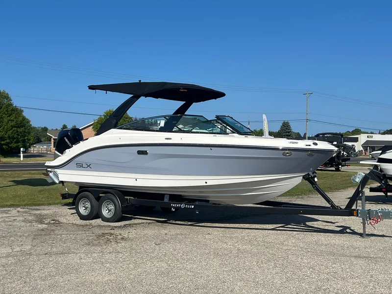 Slide: The Image of 2024 Sea Ray SLX 260 Outboard boat on trailer, parked outdoors. - 18