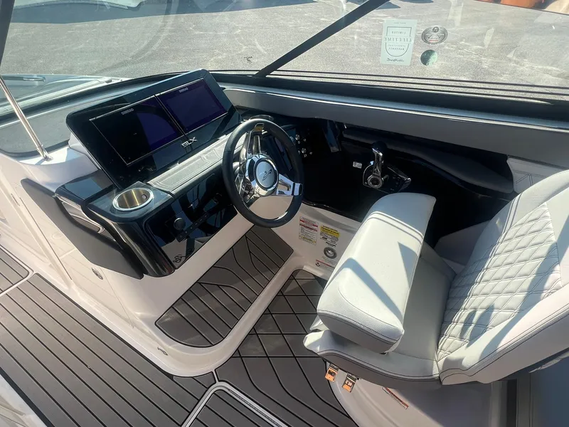 Slide: The Image of 2024 Sea Ray SLX 260 Outboard cockpit with modern steering and dashboard. - 8