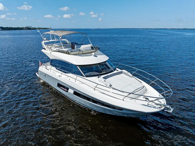 Slide: The Image of 2018 Prestige 460 yacht cruising on open water under a clear blue sky. - 1