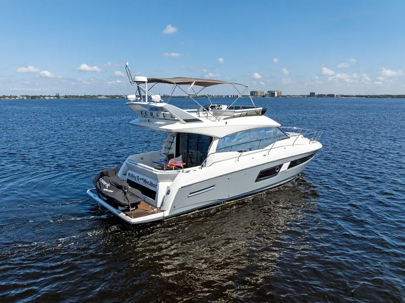 Slide: The Image of 2018 Prestige 460 yacht cruising on open water under clear blue sky. - 16