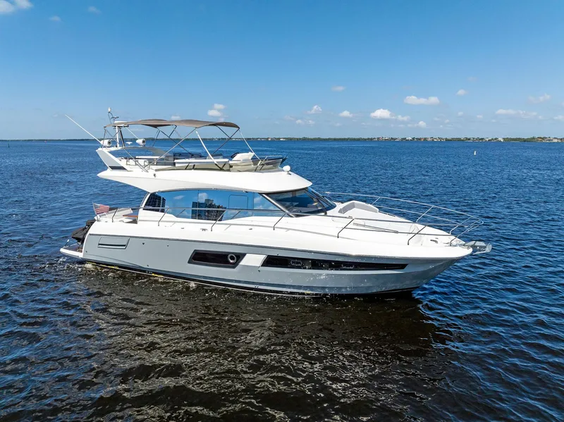 Slide: The Image of 2018 Prestige 460 yacht cruising on open water under a clear blue sky. - 18