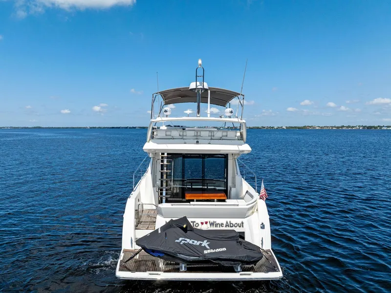 Slide: The Image of 2018 Prestige 460 yacht with jet ski on open water. - 2