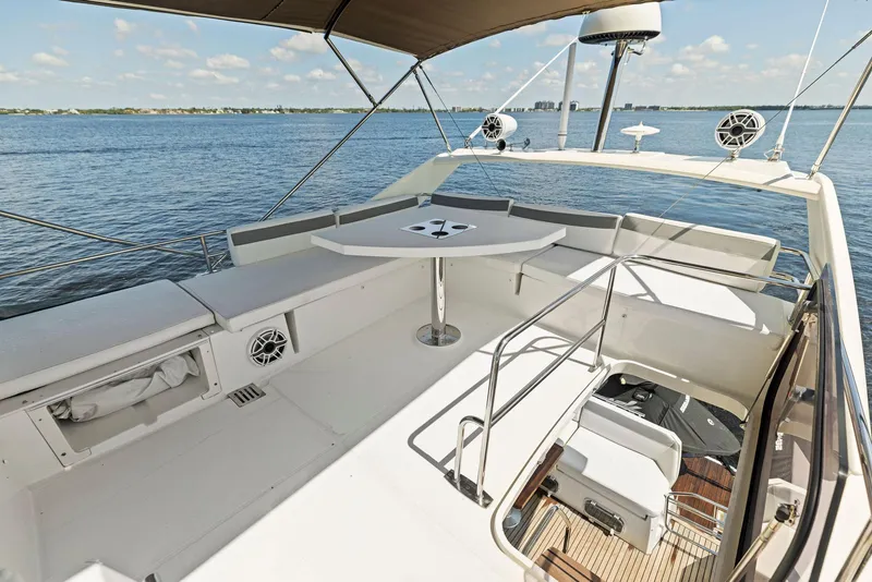 Slide: The Image of 2018 Prestige 460 yacht deck with seating and table, overlooking calm waters. - 48