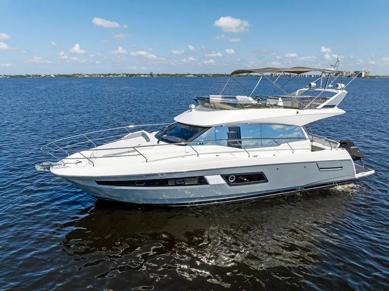 Slide: The Image of 2018 Prestige 460 yacht cruising on a calm blue sea under a clear sky. - 8