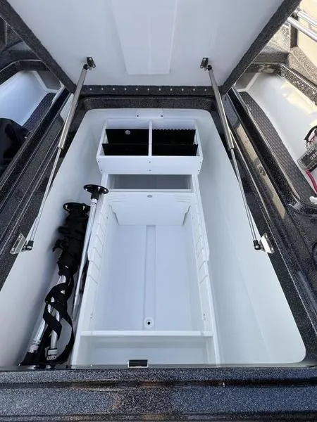 Slide: The Image of 2024 Phoenix 20 XE boat storage compartment with organized shelves and hydraulic lift. - 16