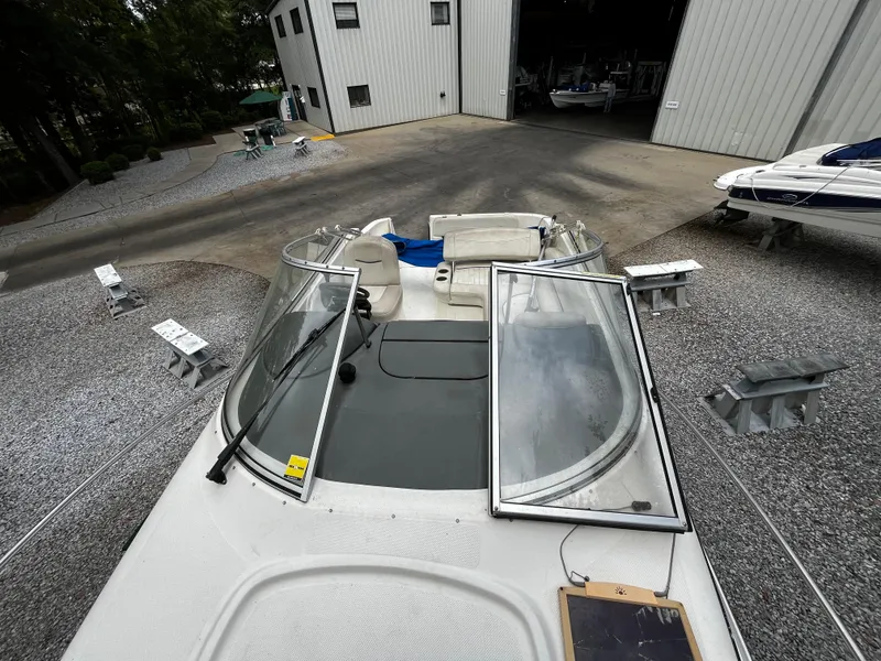Slide: The Image of 2005 Bayliner 245 boat docked at a marina with open windshield. - 13