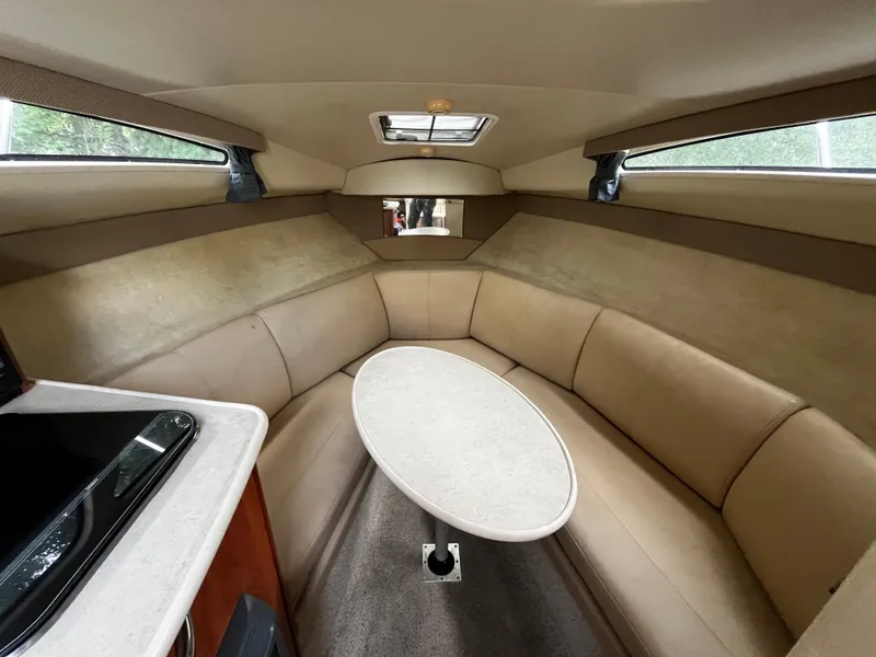 Slide: The Image of Interior of 2005 Bayliner 245 boat with beige seating and oval table. - 18