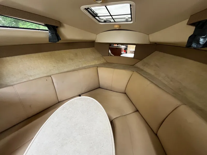 Slide: The Image of Interior of 2005 Bayliner 245 boat with beige seating and table. - 21
