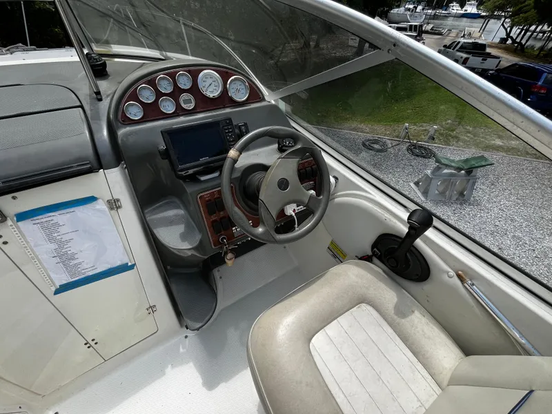 Slide: The Image of 2005 Bayliner 245 boat cockpit with steering wheel, gauges, and control panel. - 9