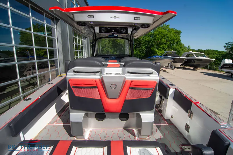 Slide: The Image of 2021 Fountain 38 SC boat interior with red and black seating, docked outdoors. - 20