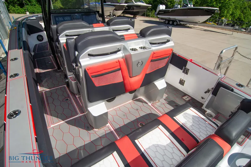 Slide: The Image of 2021 Fountain 38 SC boat interior with red and black seating, hexagonal floor pattern. - 21