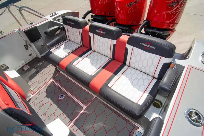 Slide: The Image of 2021 Fountain 38 SC boat interior with red and white seating and triple outboard engines. - 23