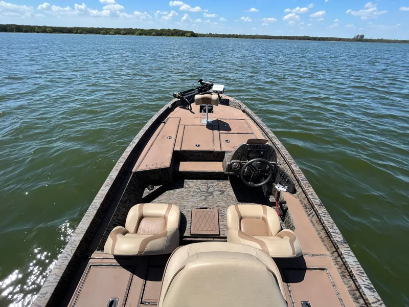 Slide: The Image of 2024 Xpress HyperLift H17 boat on a lake under a clear blue sky. - 10