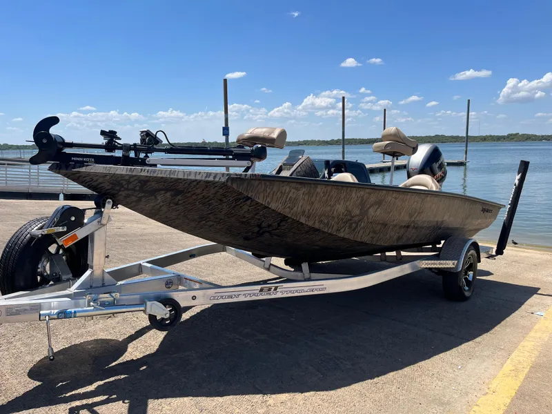 Slide: The Image of 2024 Xpress HyperLift H17 boat on trailer by a lake under clear blue sky. - 2