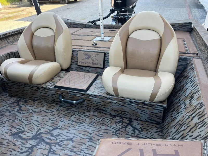 Slide: The Image of 2024 Express HyperLift H17 boat interior with two beige and brown seats. - 21
