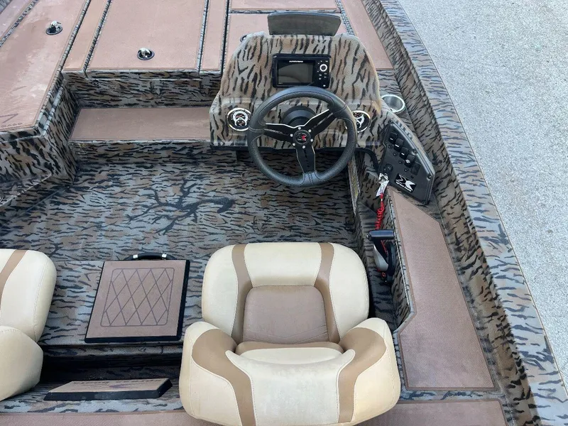 Slide: The Image of 2024 Express HyperLift H17 boat interior with camo design and beige seats. - 23