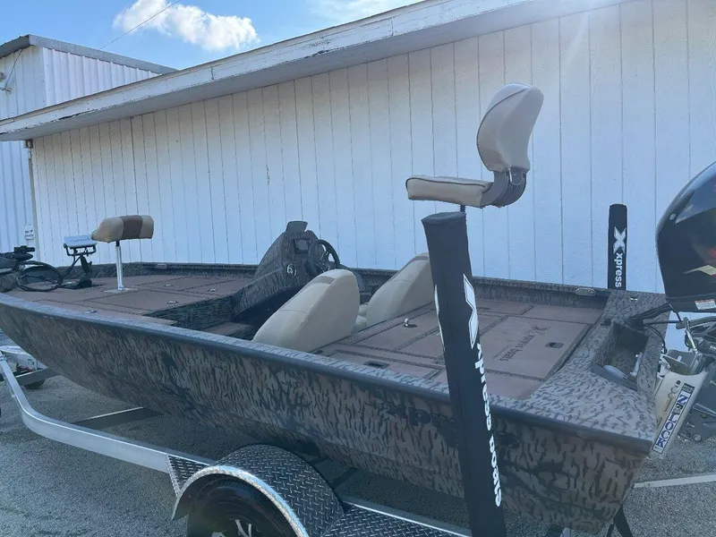 Slide: The Image of 2024 Express HyperLift H17 fishing boat with camo design and beige seats. - 31