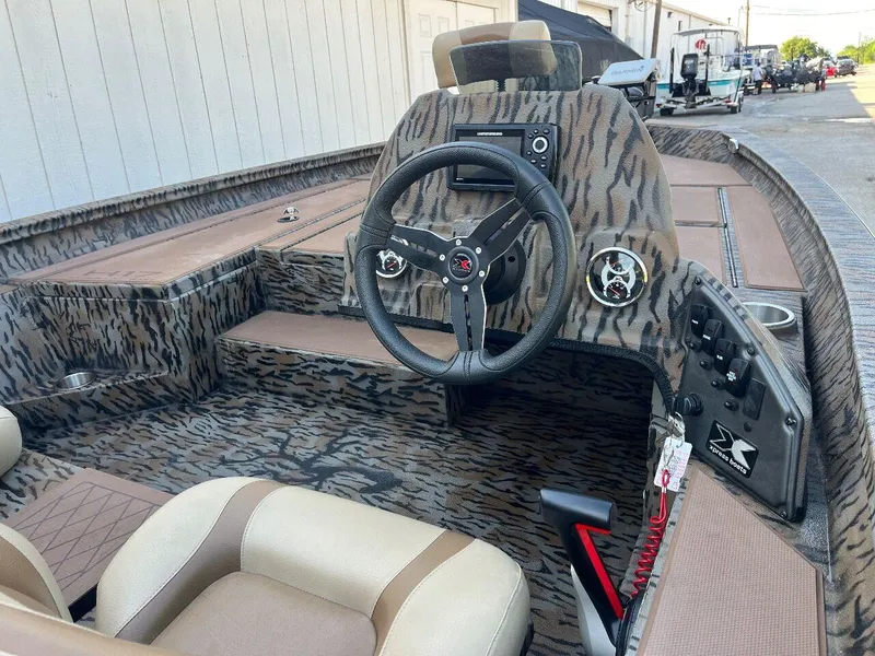 Slide: The Image of 2024 Express HyperLift H17 boat interior with camo design and steering console. - 42