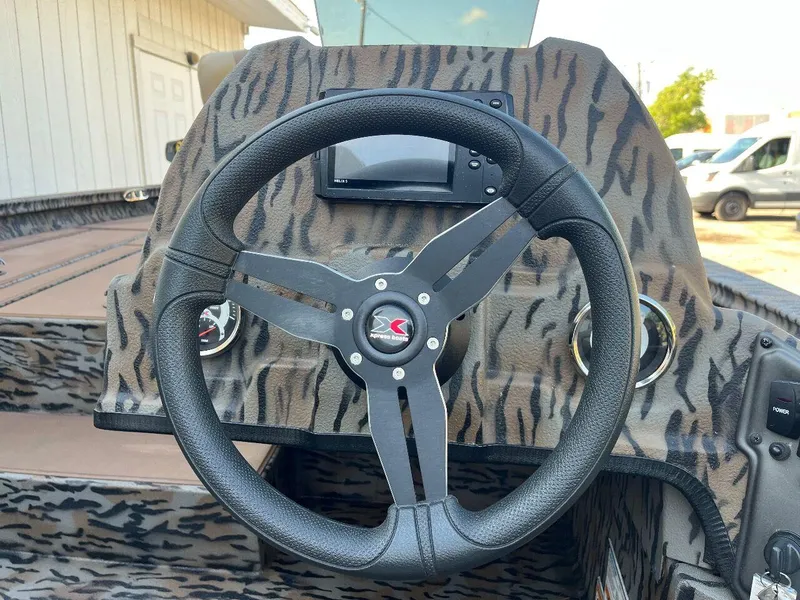 Slide: The Image of 2024 Express HyperLift H17 boat steering wheel and dashboard with camouflage design. - 43
