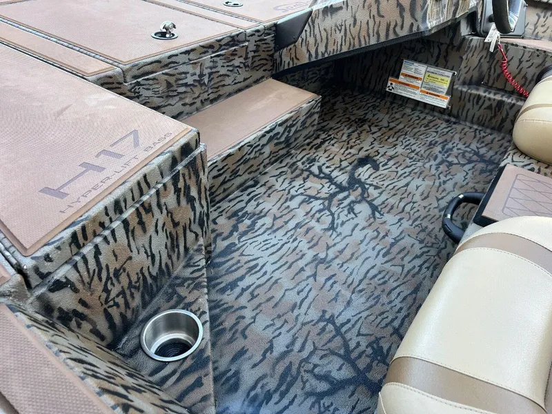Slide: The Image of 2024 Express HyperLift H17 boat interior with camo pattern and beige seats. - 47