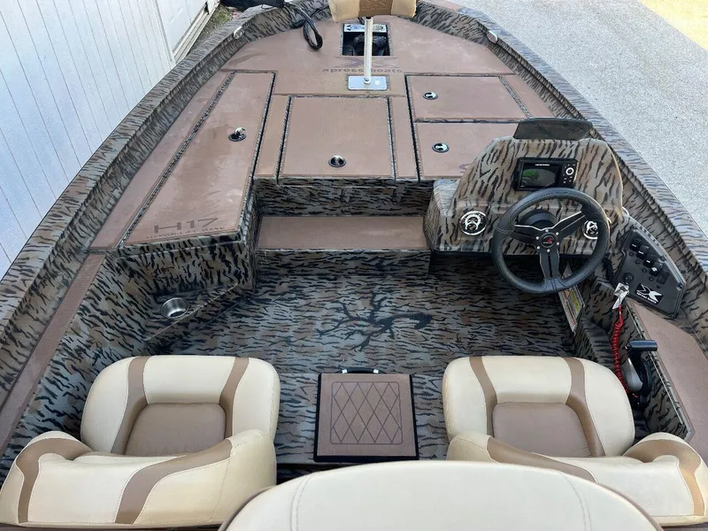Slide: The Image of 2024 Express HyperLift H17 boat interior with camo design and dual seats. - 48