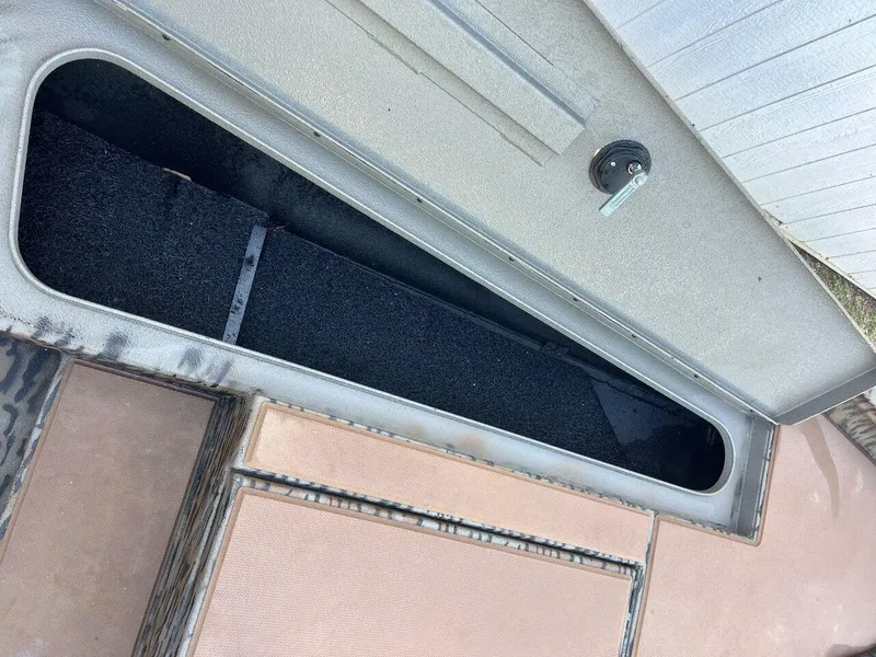 Slide: The Image of 2024 Express HyperLift H17 boat storage compartment with open lid and key lock. - 58