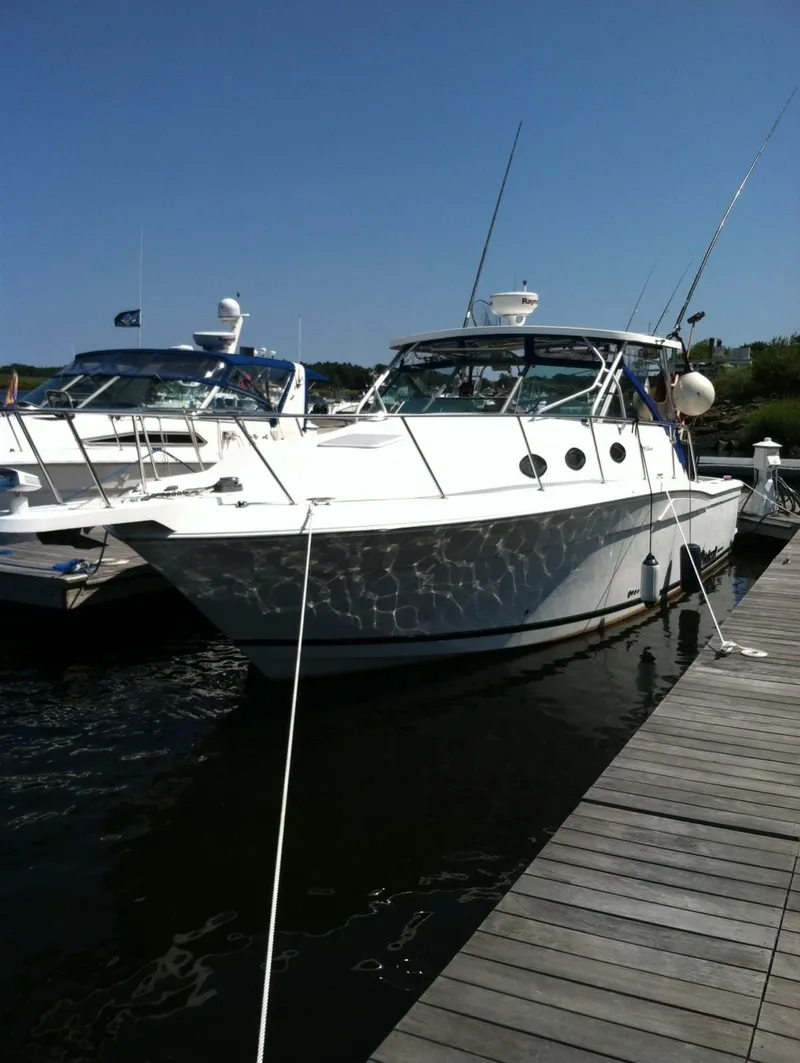 Slide: The Image of 2000 Wellcraft 330 Coastal boat docked at marina under clear blue sky. - 1