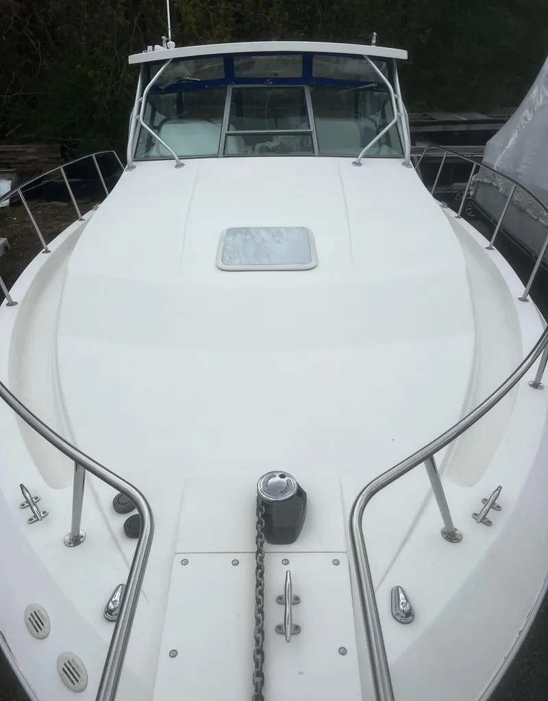 Slide: The Image of 2000 Wellcraft 330 Coastal boat, white deck, stainless steel railings, front view. - 11