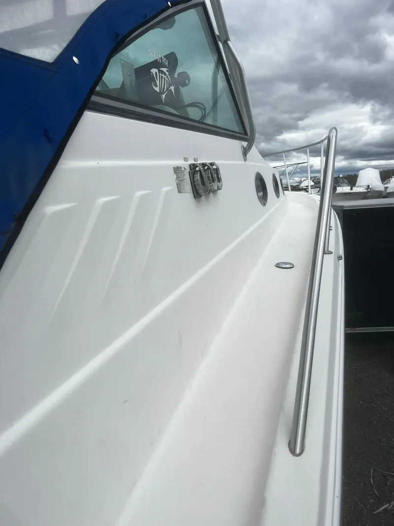 Slide: The Image of 2000 Wellcraft 330 Coastal boat with sleek white exterior and stainless steel railing. - 12