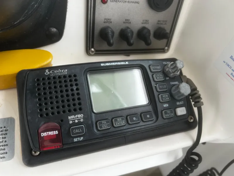 Slide: The Image of Cobra Marine radio on 2000 Wellcraft 330 Coastal boat dashboard, featuring distress button and controls. - 18