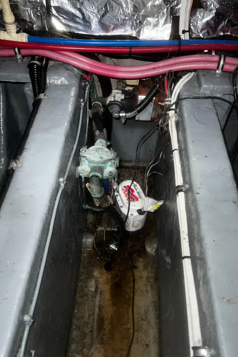 Slide: The Image of Engine compartment of a 2000 Wellcraft 330 Coastal boat, showing mechanical components and wiring. - 25