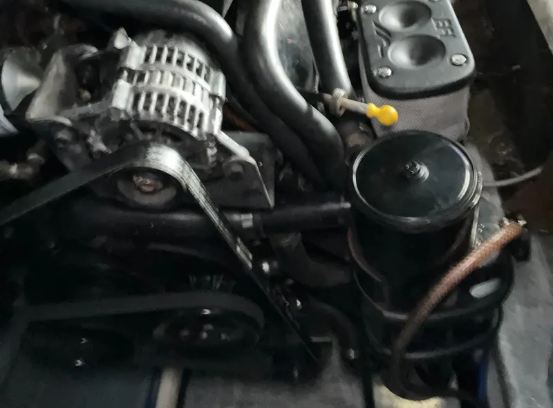 Slide: The Image of Engine components of a 2000 Wellcraft 330 Coastal boat, featuring belts and hoses. - 27